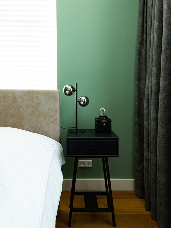 slaapkamer groene muur donkere gordijnen houten jaloezieen wit